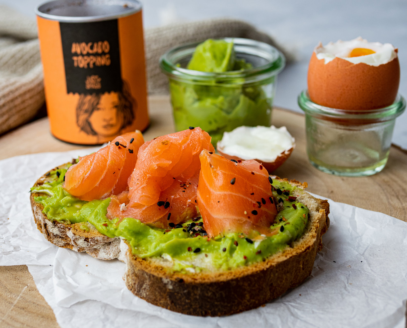 Avocado-Aufstrich mit Lachs auf getoastetem Brot, garniert mit Tomaten und Kren.