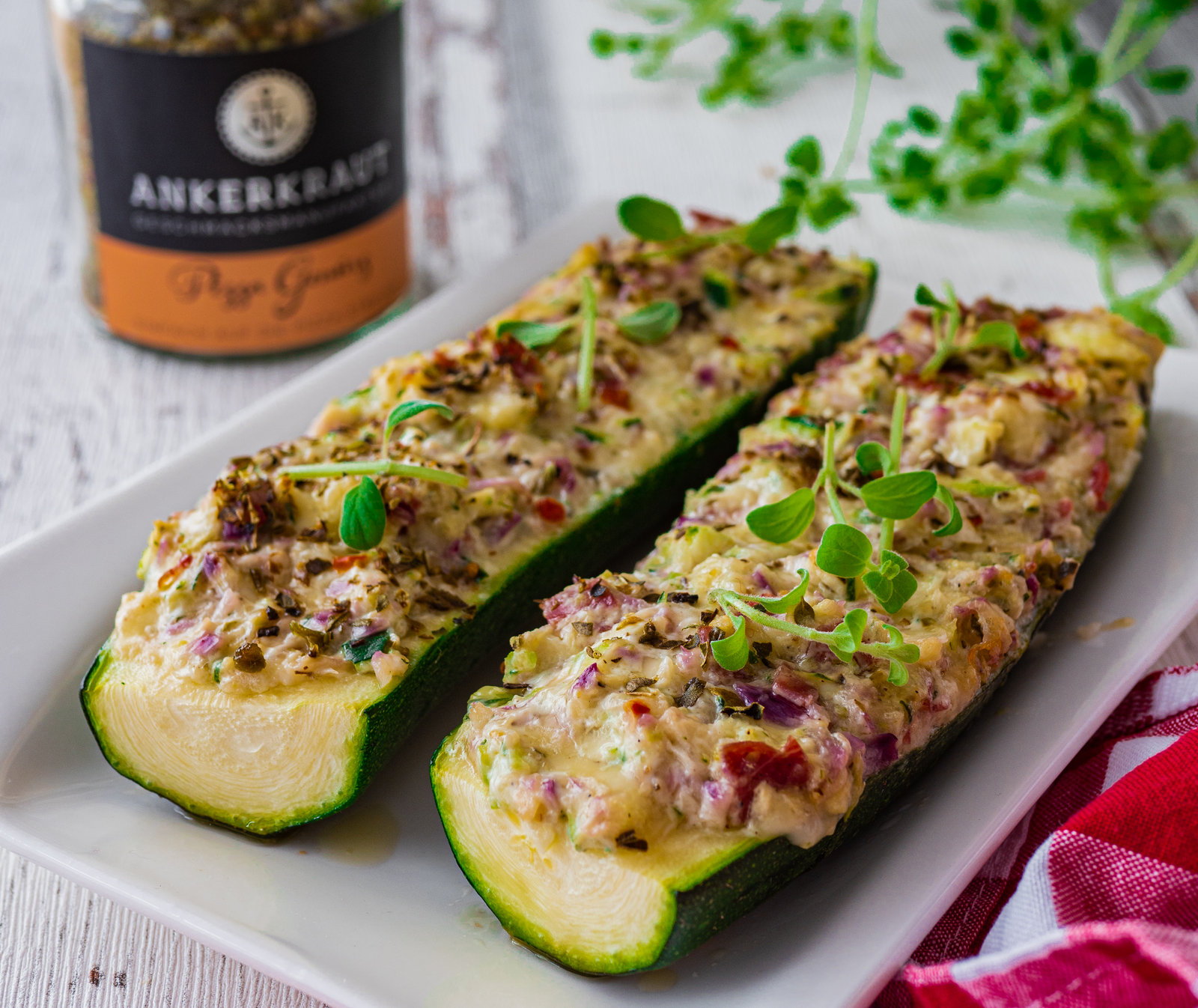 Gefüllte Zucchini-Schiffchen in einer Auflaufform, goldbraun gebacken.
