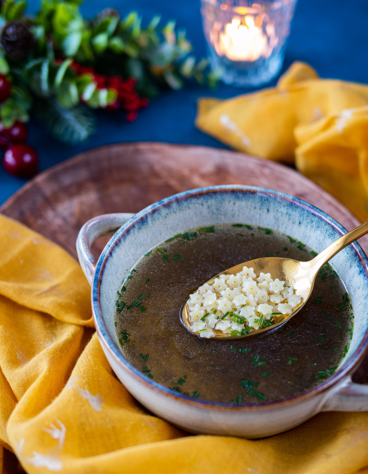 Eine Schale mit klarer Rindsuppe, garniert mit frischen Kräutern.