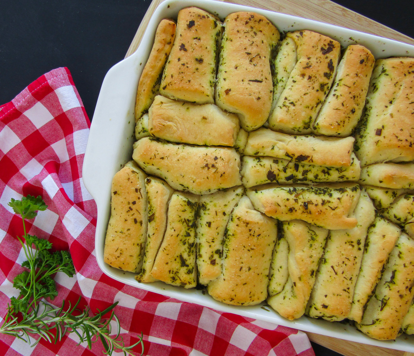 Ein frisch gebackenes Faltenbrot mit Kräuterbutter, in einer Backform angerichtet.