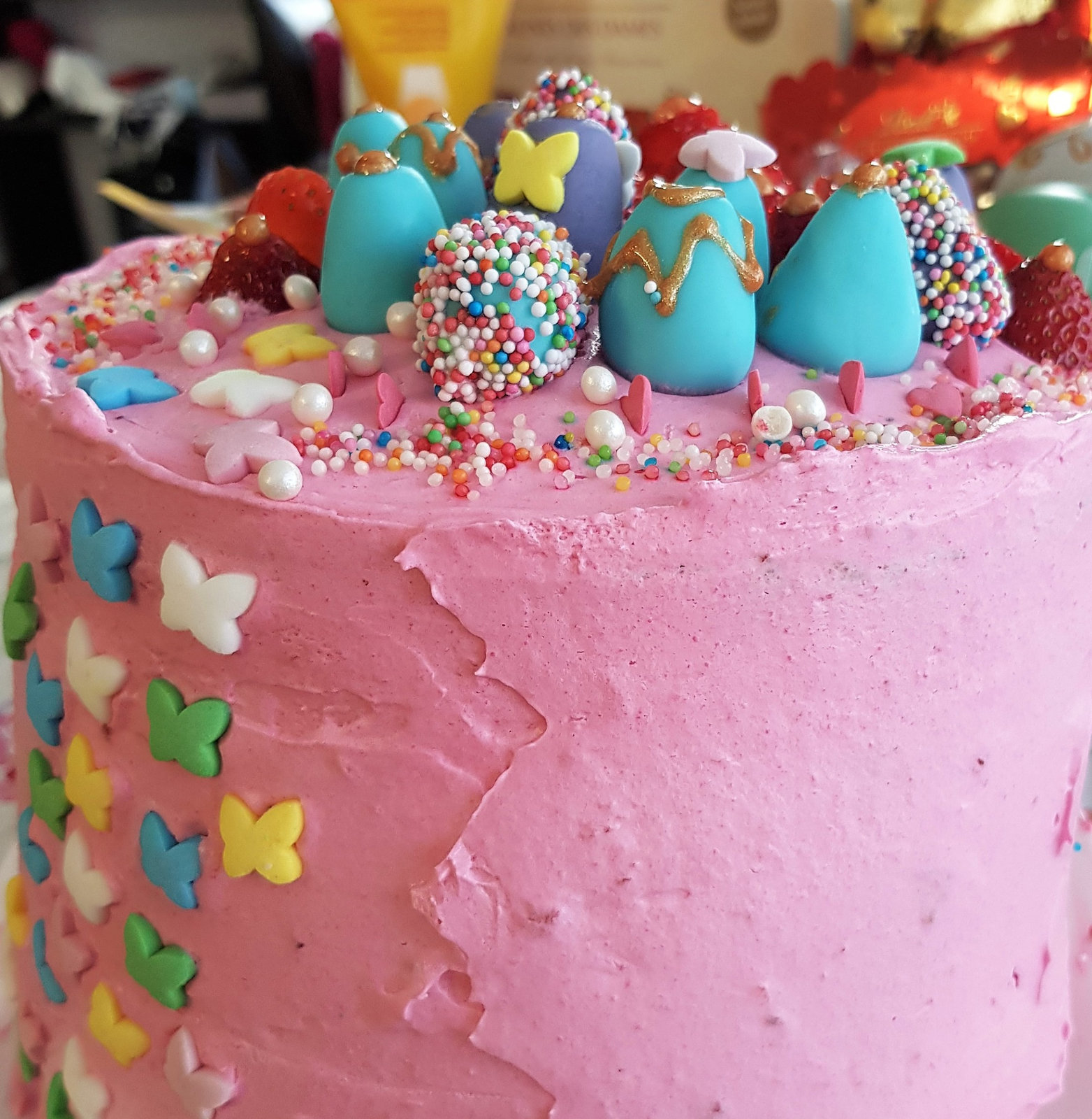 Eine angeschnittene Erdbeer-Likör-Torte mit mehreren Schichten Biskuit, Creme und Erdbeermarmelade, garniert mit frischen Erdbeeren.
