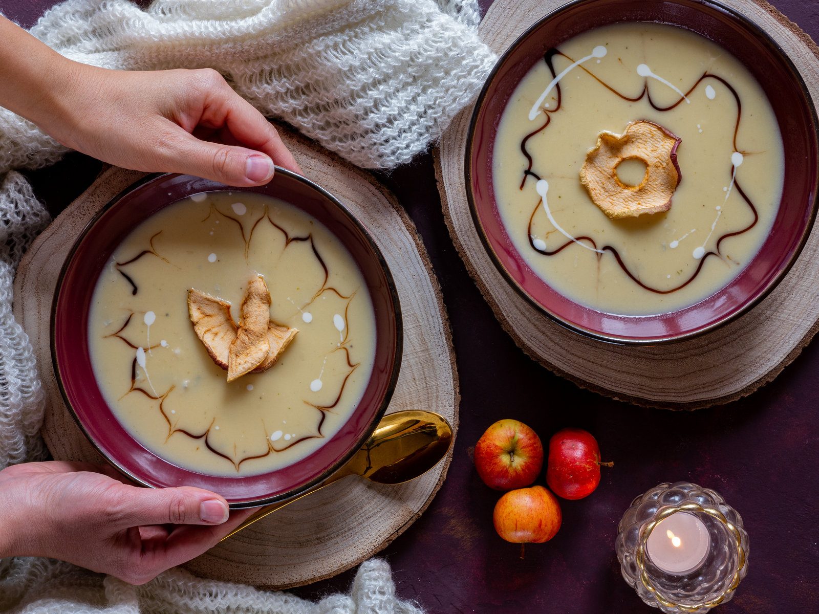 Eine Schale Apfel-Sellerie-Cremesuppe, garniert mit frischen Kräutern