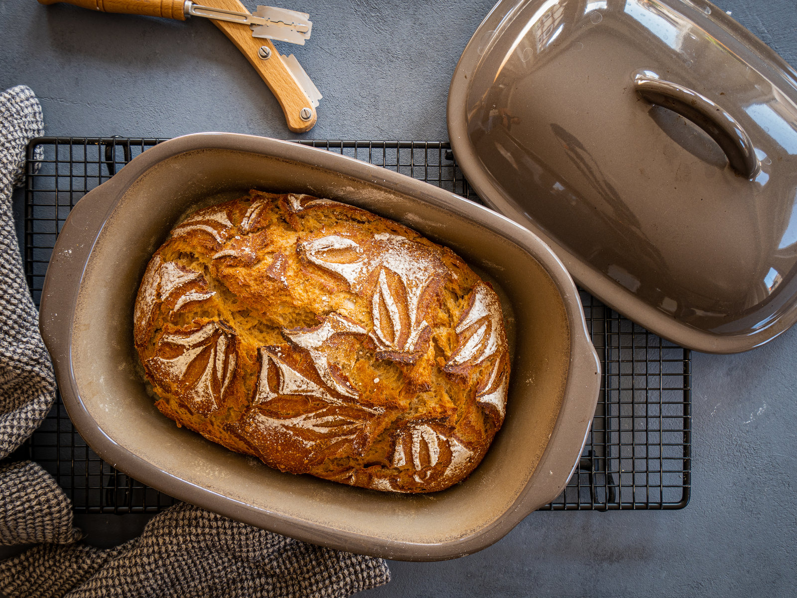 Ein frisch gebackenes, rustikales Dinkelbrot mit knuspriger Kruste auf einem Holzbrett.