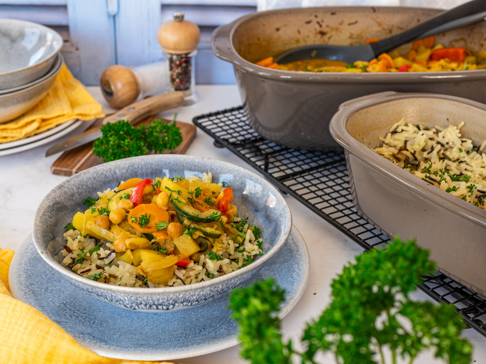 Ein Teller mit cremigem Gemüse-Curry und Reis, garniert mit frischen Kräutern.