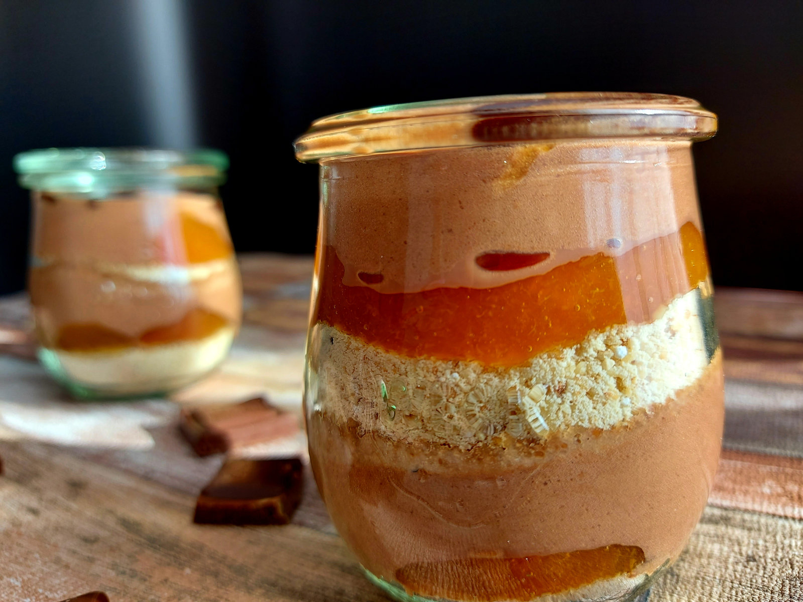 Zserbó im Glas mit Schichten aus Keks, Marmelade und Schoko-Sahne, dekoriert mit Schokoblättern