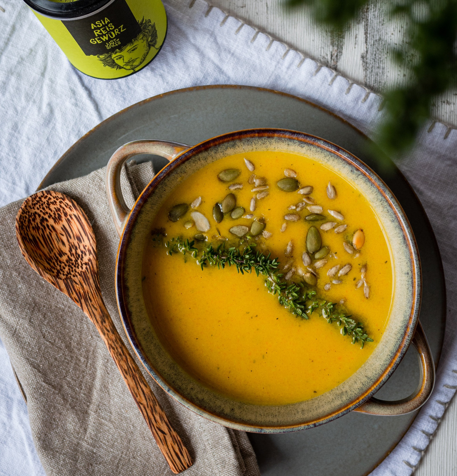 Eine Schale mit cremiger Gemüsesuppe, garniert mit frischen Kräutern.