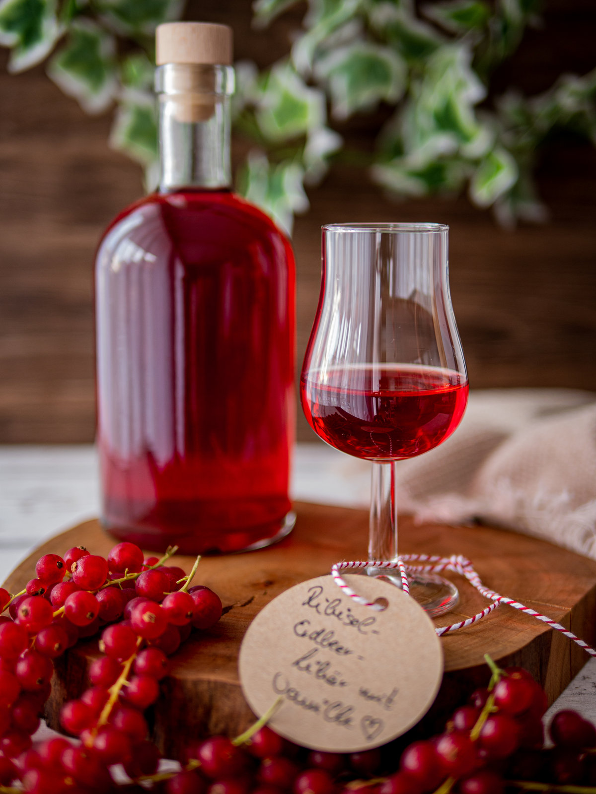 Selbstgemachter Ribisellikör mit Erdbeeren und Vanille in einer Glasflasche