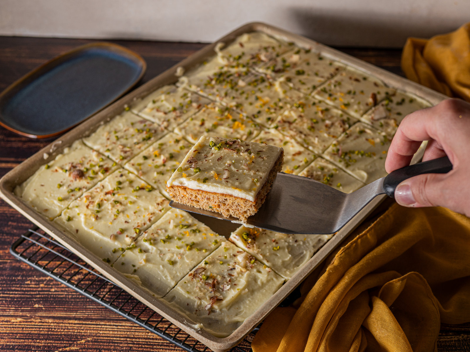 Ein Stück saftiger Karottenkuchen mit Frischkäse-Topping auf einem Teller.