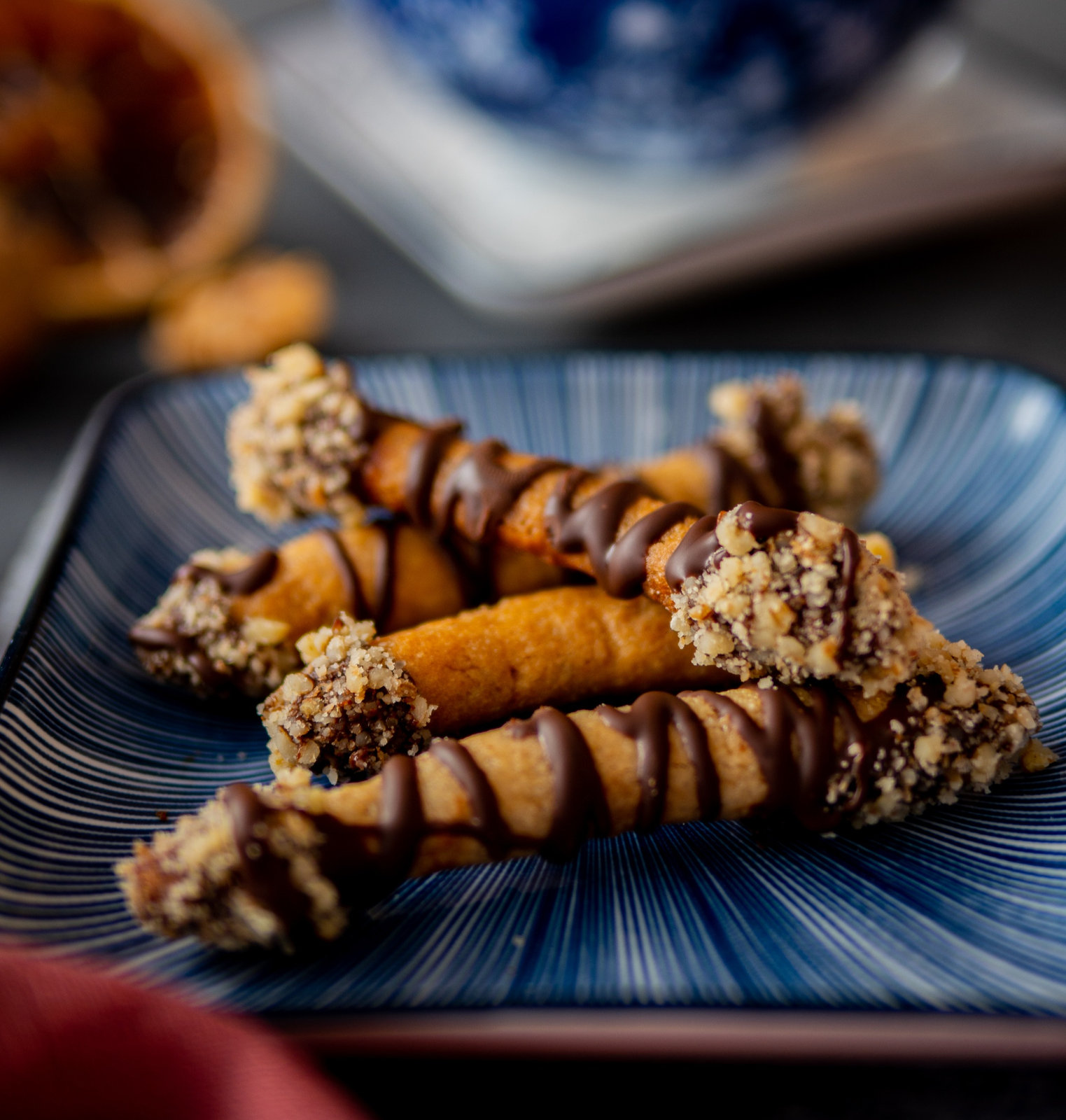 Marzipan-Walnuss-Stäbchen mit Schokoladenüberzug und Walnussstreuseln auf einem Backblech