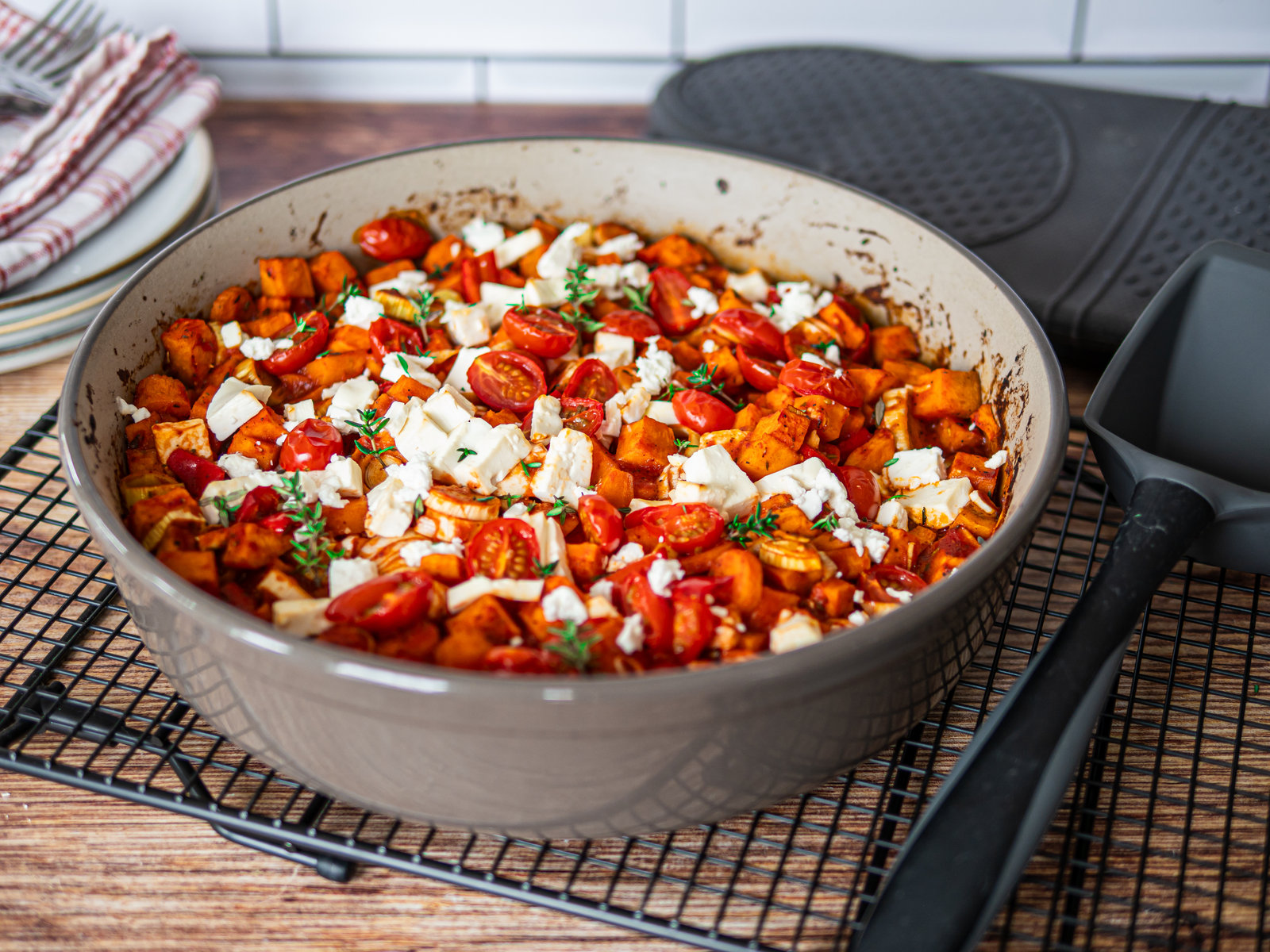 Ein herzhafter Süßkartoffel-Auflauf mit Feta, Paprika und Tomaten, serviert mit Spiegeleiern.