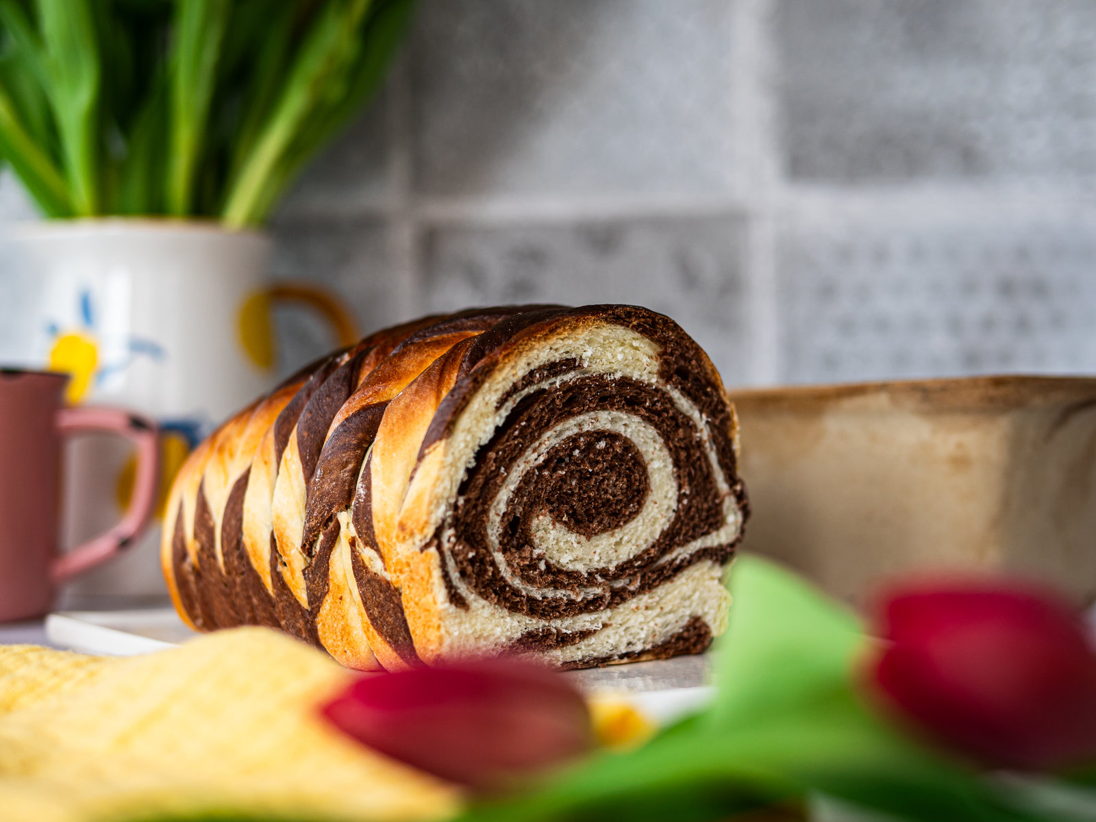 Ein angeschnittener Zebra Zopf mit hellem und dunklem Teig, der ein Zebramuster bildet.