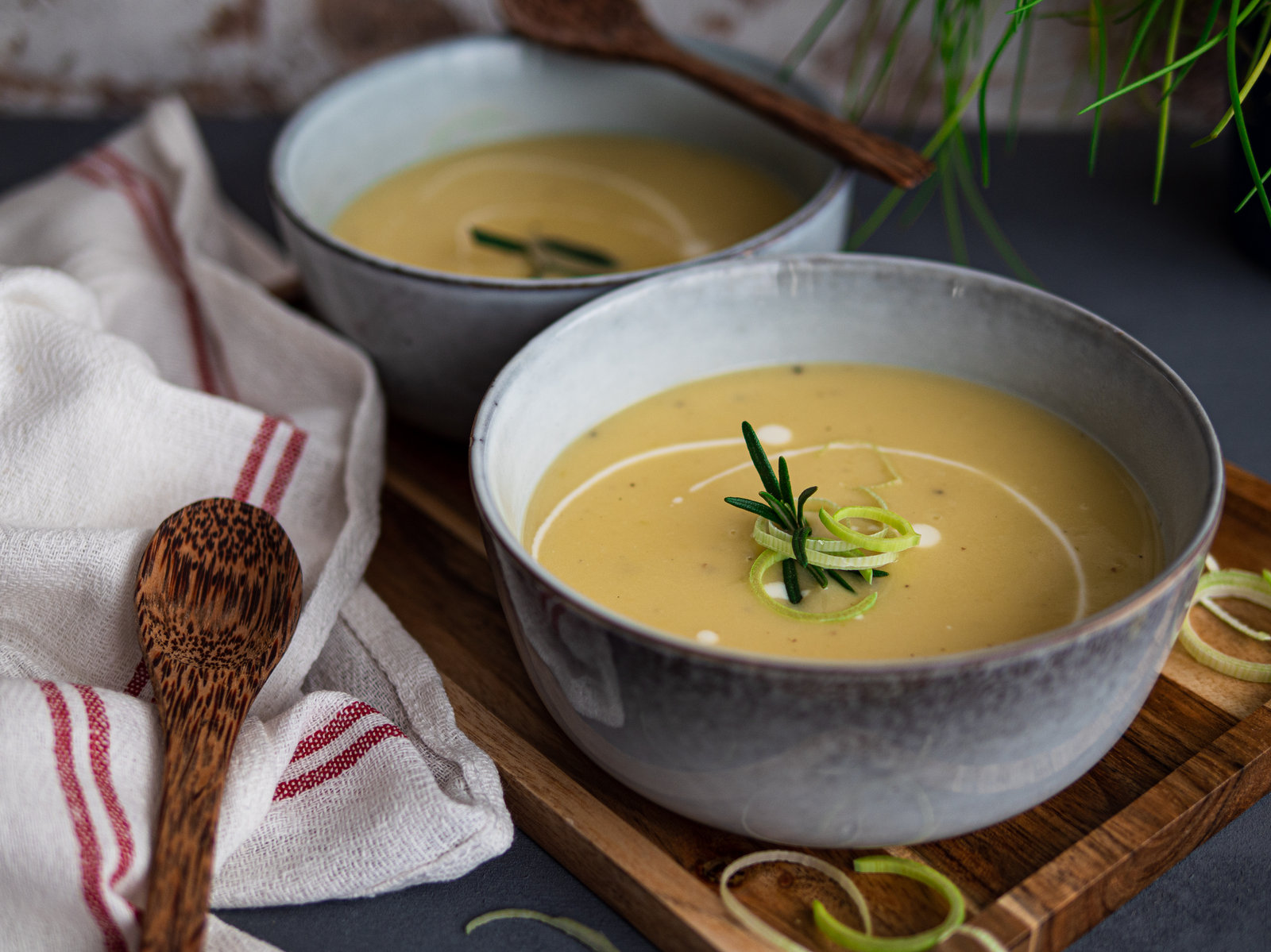 Eine Schale cremige Lauchcremesuppe, garniert mit frischen Kräutern.