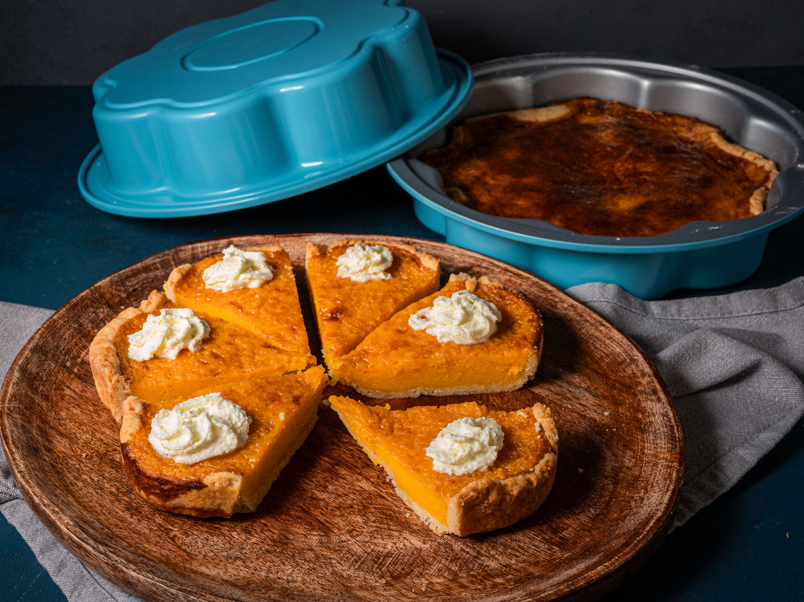 Ein Stück Pumpkin Pie mit Sahne und Vanilleeis auf einem Teller.
