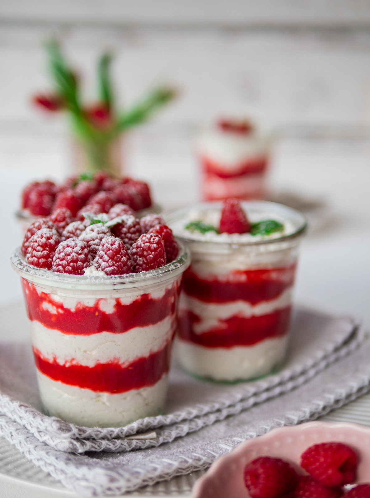 Himbeer-Quark-Dessert im Glas mit frischen Himbeeren und Minze dekoriert