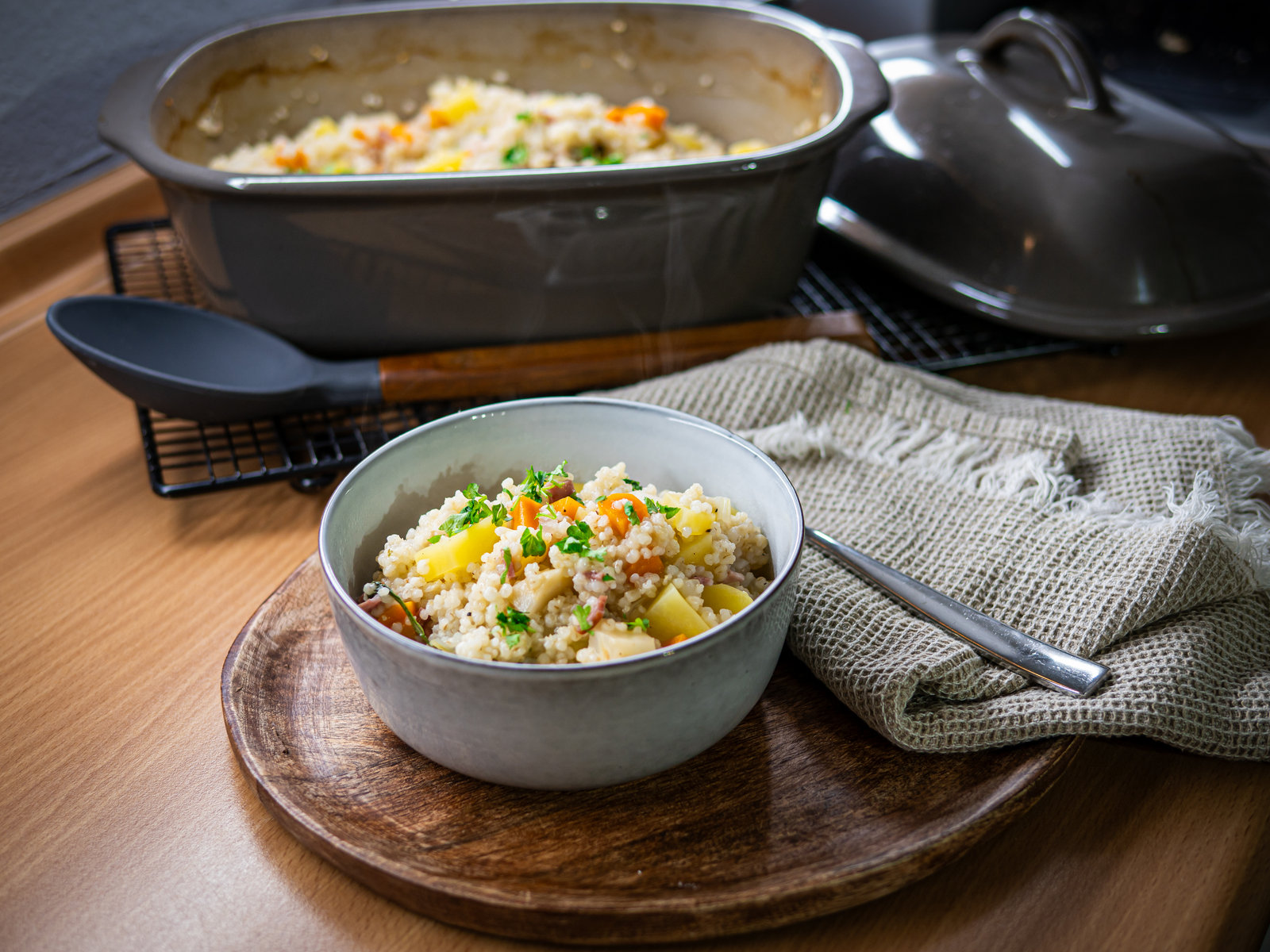 Eine Schale dampfende Gerstlsuppe mit Gemüse und Petersilie, angerichtet in einem rustikalen Ambiente.