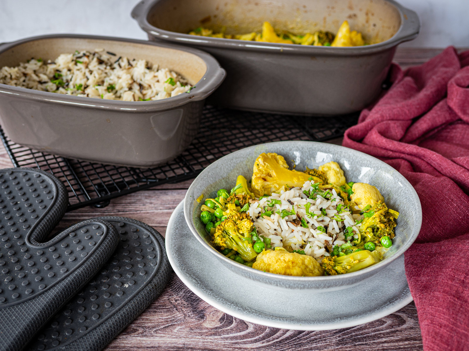 Vegetarisches Curry mit Reis in einer Auflaufform, garniert mit frischen Kräutern.