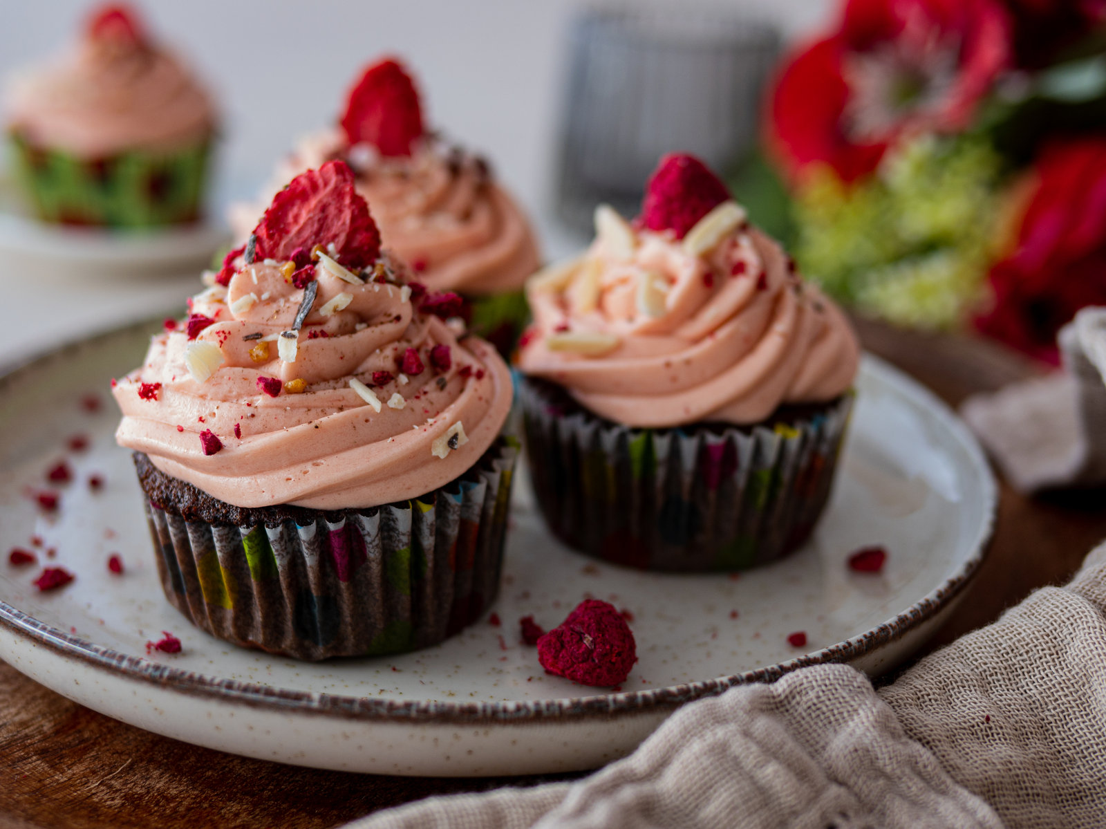 Schoko-Erdbeer-Cupcakes mit rosa Frosting und frischen Beeren dekoriert