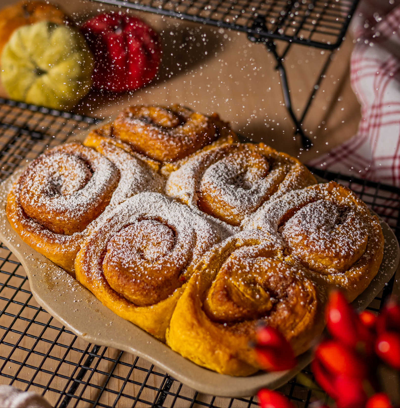 Kürbis-Zimtschnecken mit Puderzucker bestreut, in einer runden Backform
