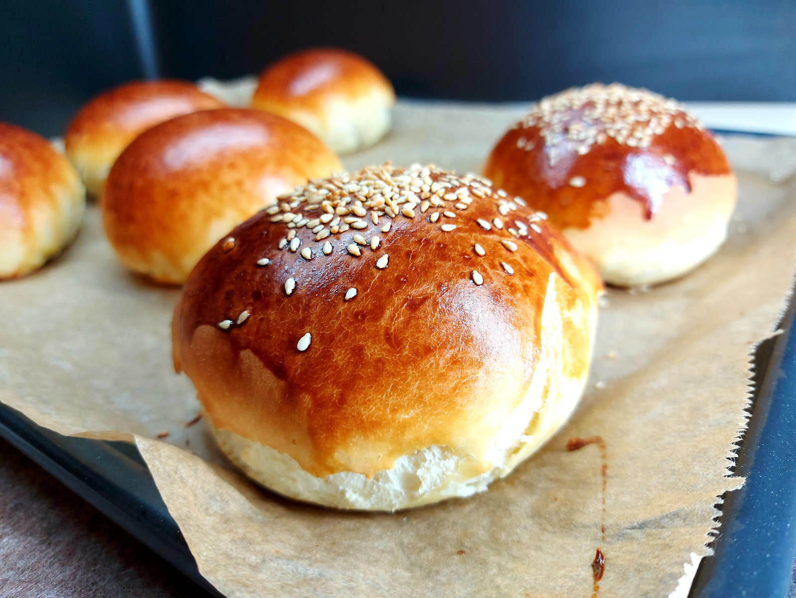 Frisch gebackene, goldbraune Burger Brötchen auf einem Backblech