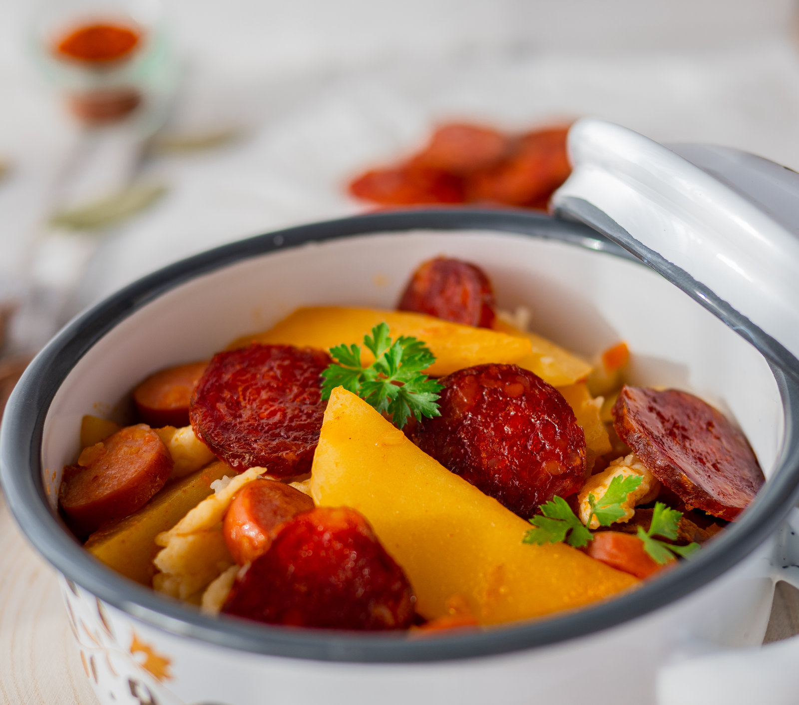 Ungarisches Kartoffelgulasch mit Spätzle in einer Schüssel, garniert mit frischer Petersilie.