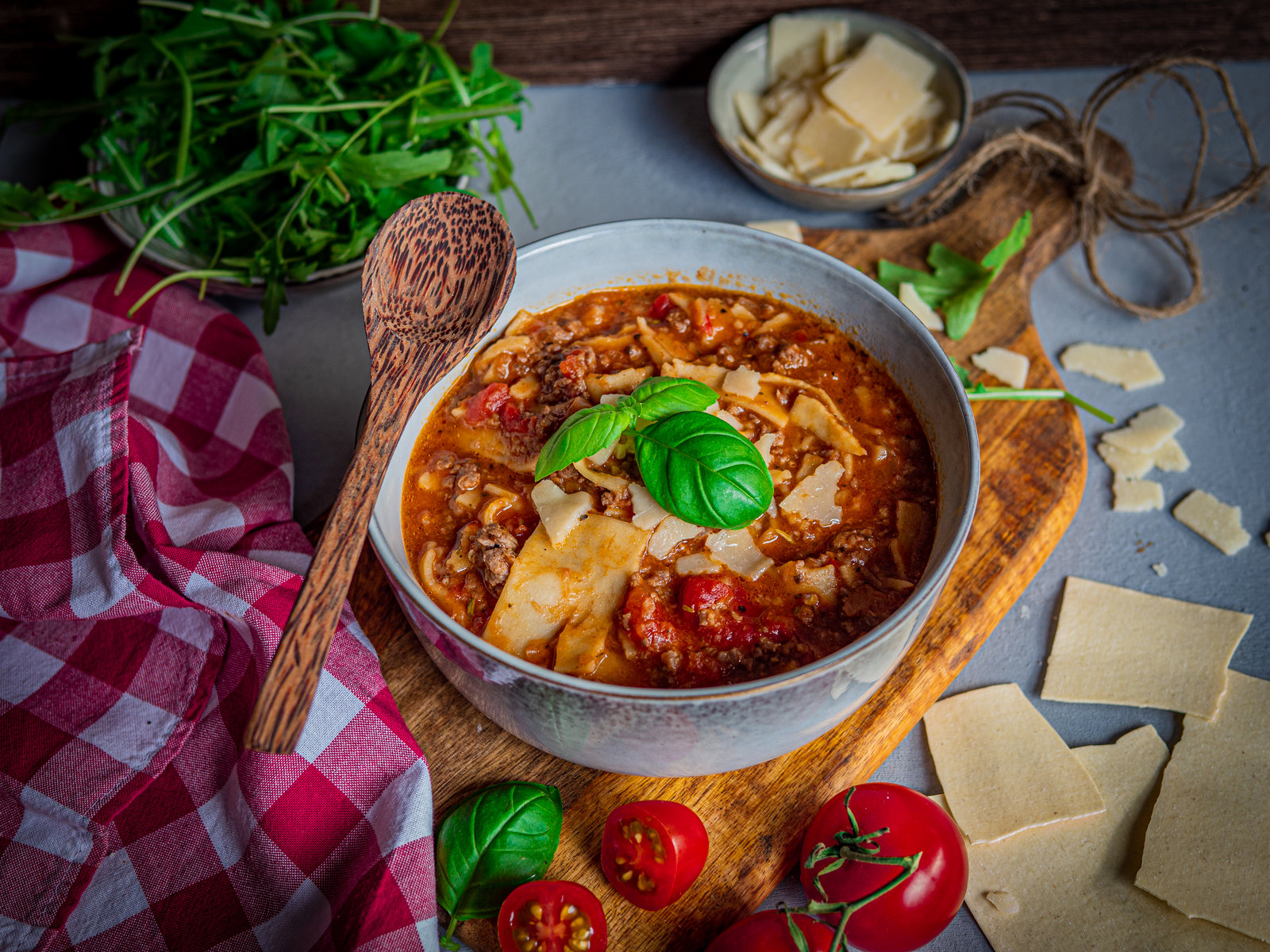 Ein dampfender Topf mit Lasagne-Eintopf, garniert mit frischen Kräutern und geriebenem Parmesan.