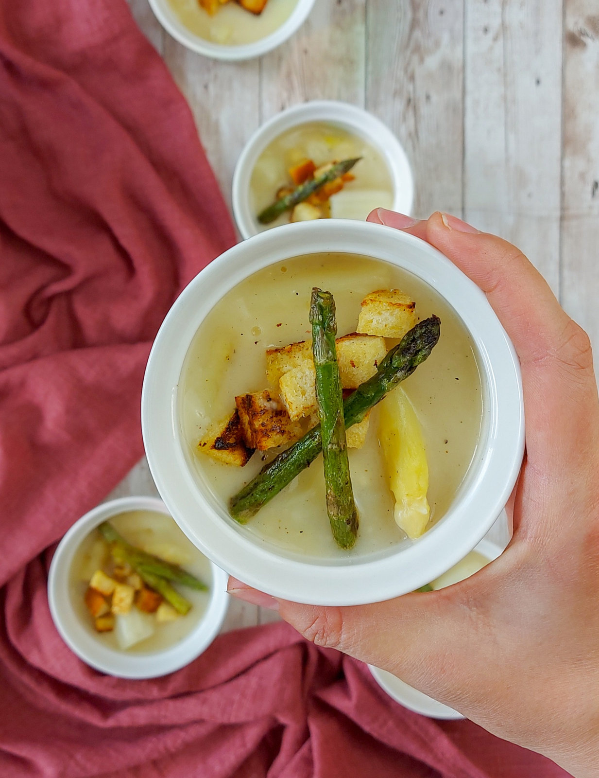 Eine Schale cremige Spargelsuppe, garniert mit frischem Schnittlauch und knusprigen Croutons.