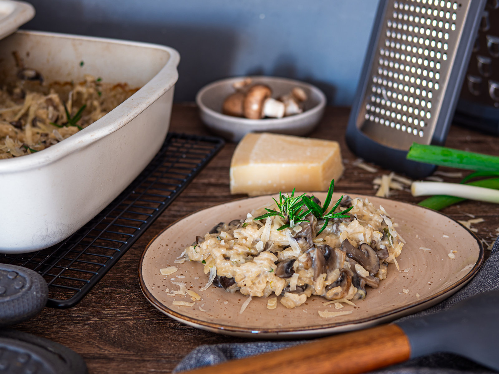 Cremiges Pilzrisotto mit frischen Champignons und Kräutern in einer Ofenhexe angerichtet.
