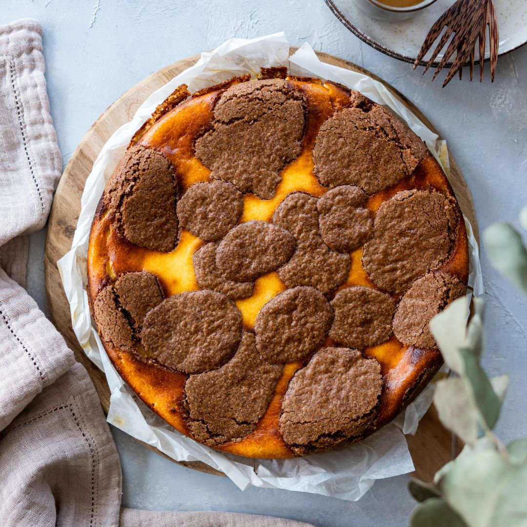 Ein Stück Käsekuchen mit Schokoboden auf einem Teller