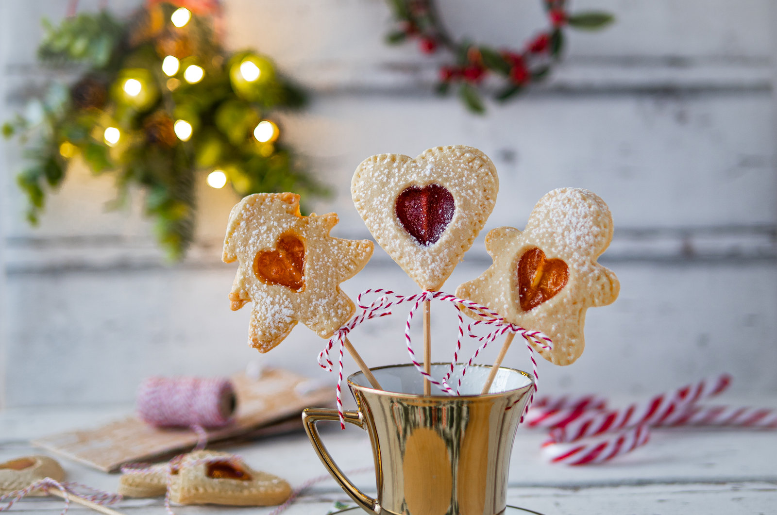 Linzer Kekse am Stiel mit Marmeladenfüllung und Puderzucker bestreut