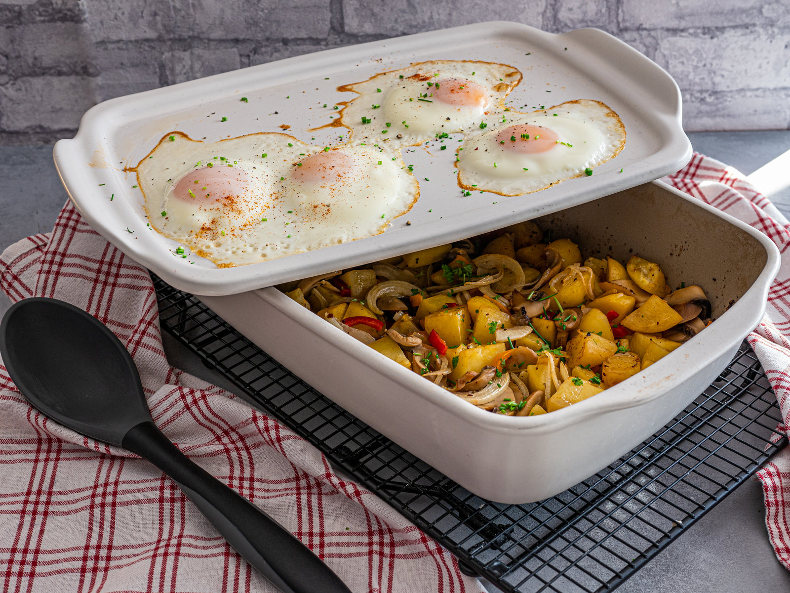 Vegetarisches Gröstl mit Kartoffeln, Paprika, Champignons und Spiegelei in einer Ofenhexe