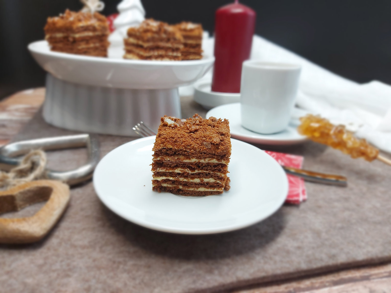 Anschnitt eines Stücks Schoko Marlenka mit mehreren Teigschichten und heller Creme