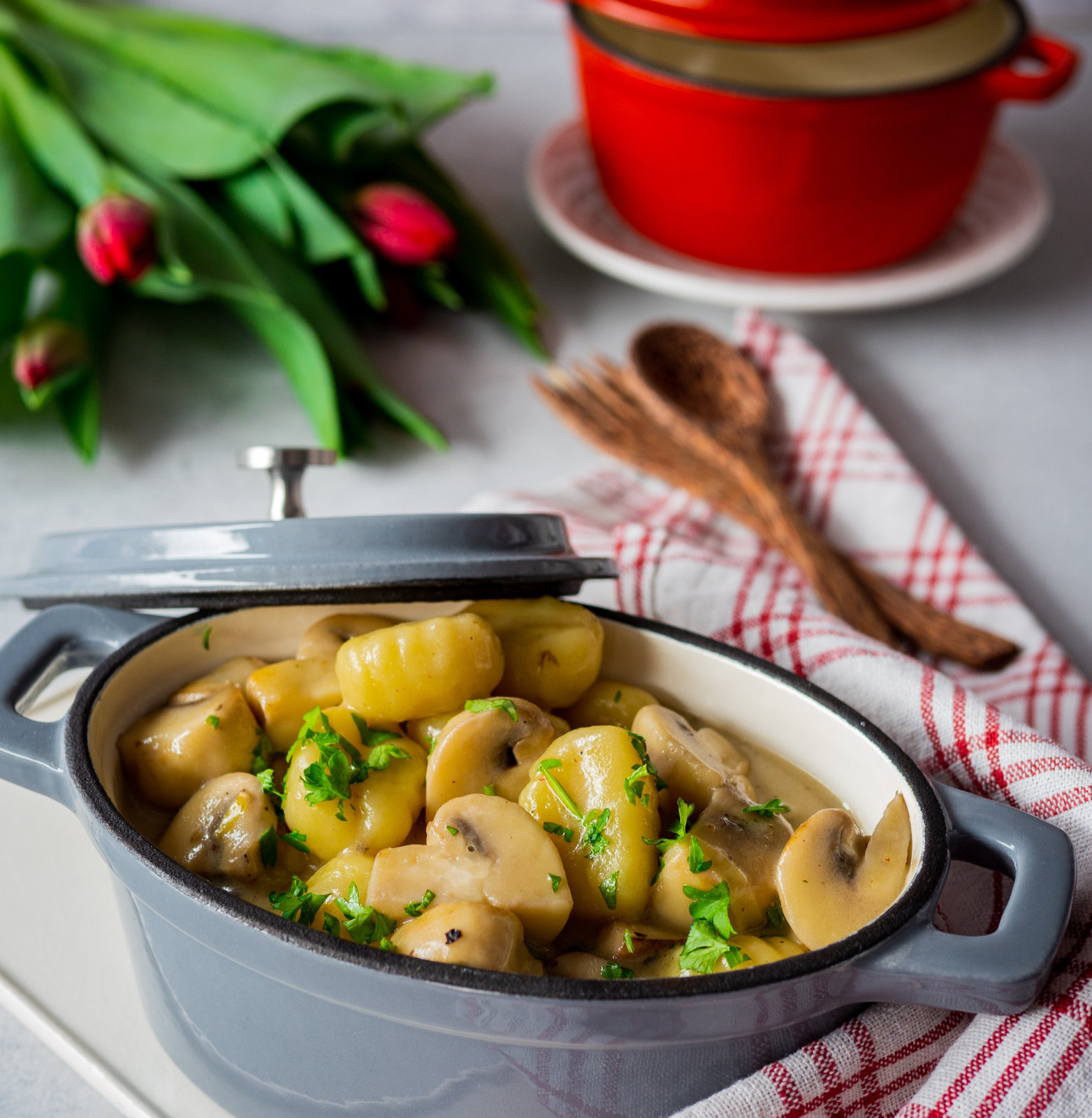 Cremige Pilzrahmsauce mit Gnocchi, garniert mit frischer Petersilie in einem Topf.