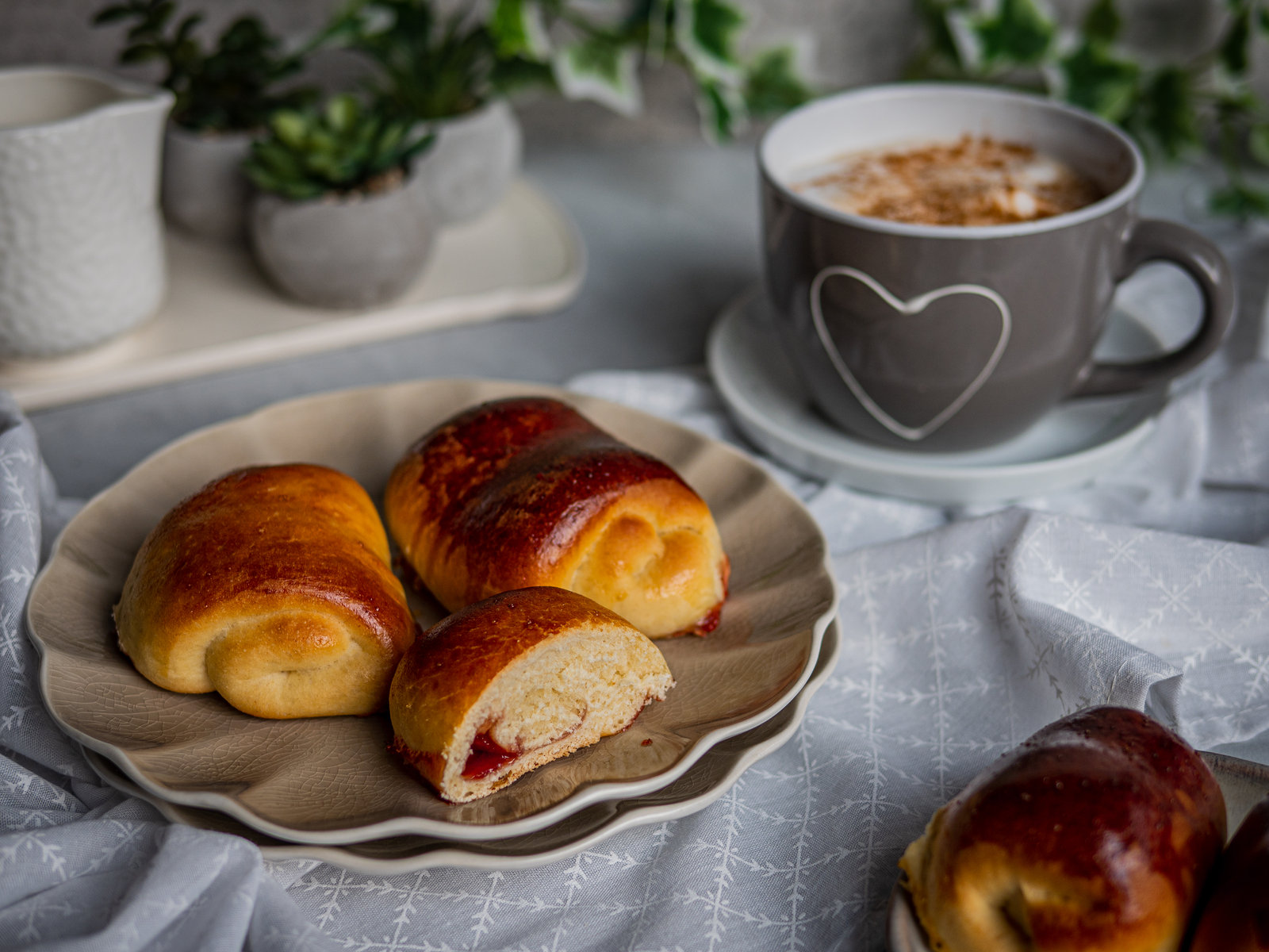 Ungarische Buchteln mit Marmeladenfüllung auf einem Backblech, goldbraun gebacken und mit Puderzucker bestreut.