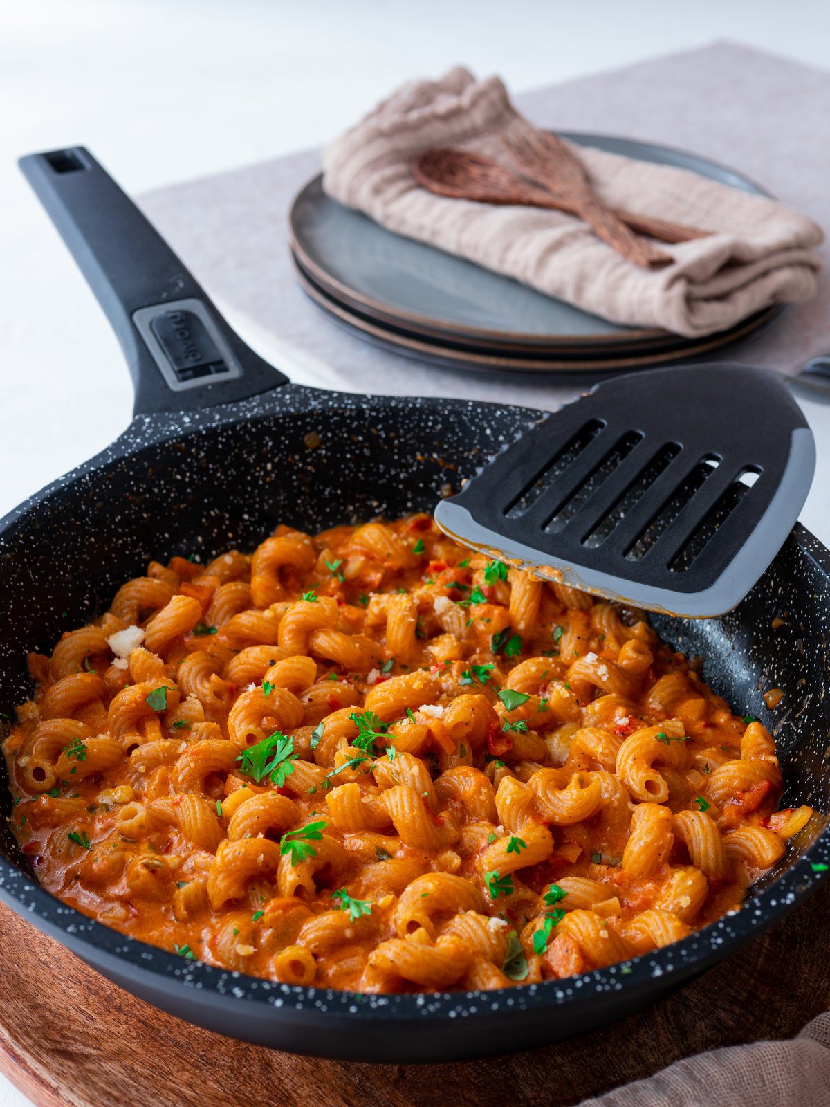 Eine One Pot Nudelpfanne mit Tomatensauce und frischen Kräutern, servierfertig in einer Pfanne.