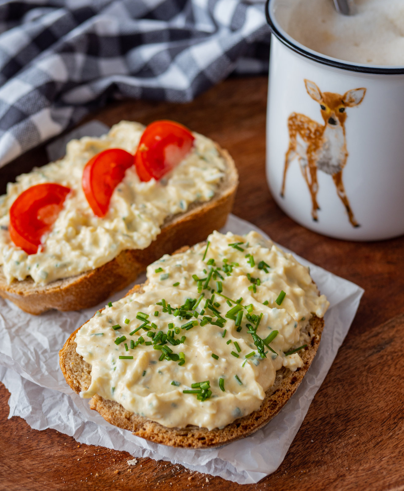 Cremiger Eier-Aufstrich in einer Schale, garniert mit frischem Schnittlauch, daneben Brot.