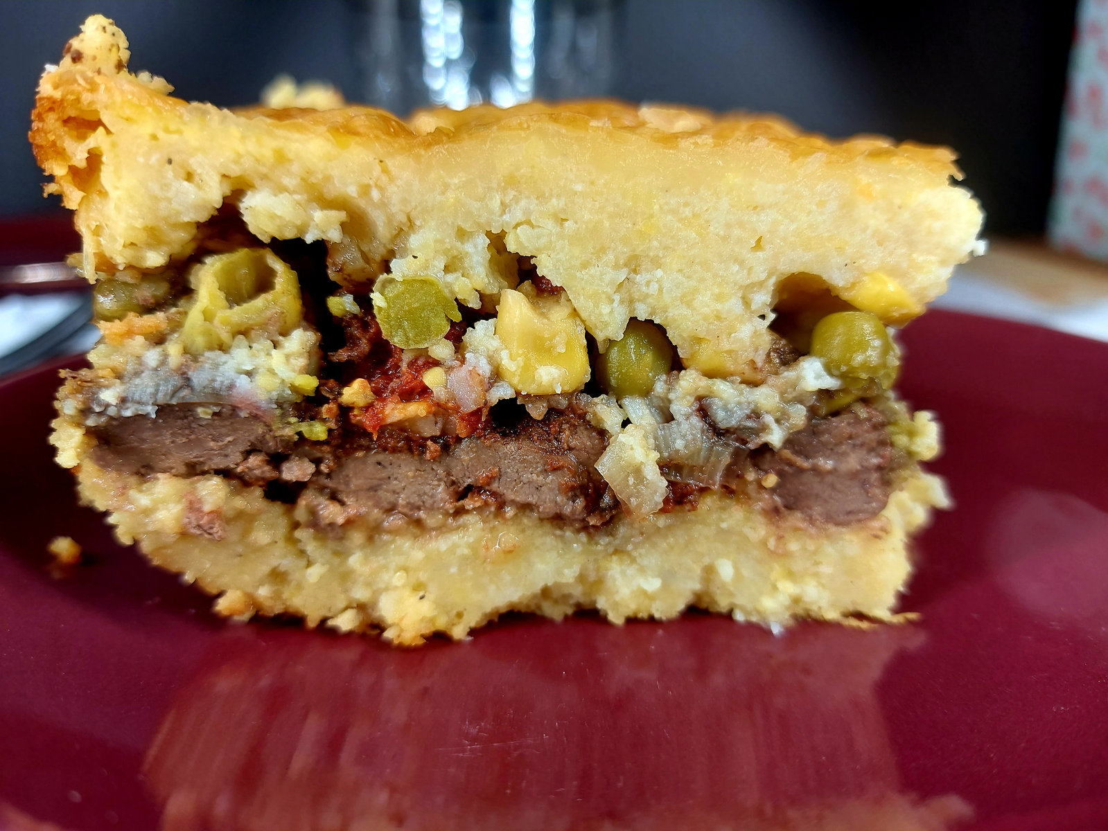 Ein goldbraun gebackener Polenta-Leber-Auflauf in einer Auflaufform, mit geschmolzenem Käse überbacken.